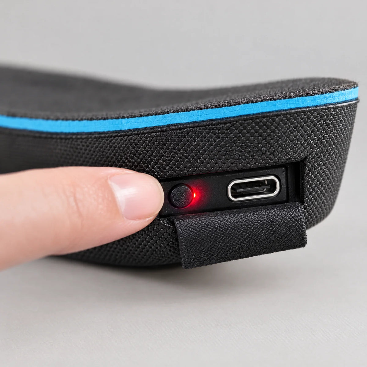 Heel of the heated insole with a switch with red LED, USB-C port and pull tab